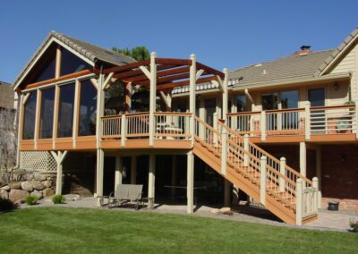 Pergola deck stairs leading down to the backyard of a Colorado home